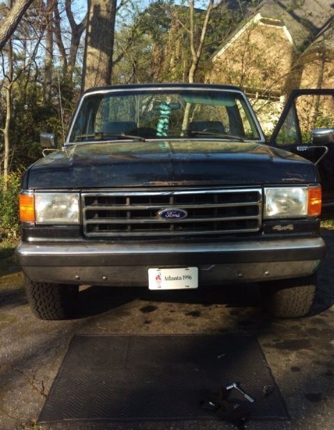 1988 Ford Bronco - Front view of a black Ford Bronco with a chrome grille and a "Atlanta 1996" license plate.
