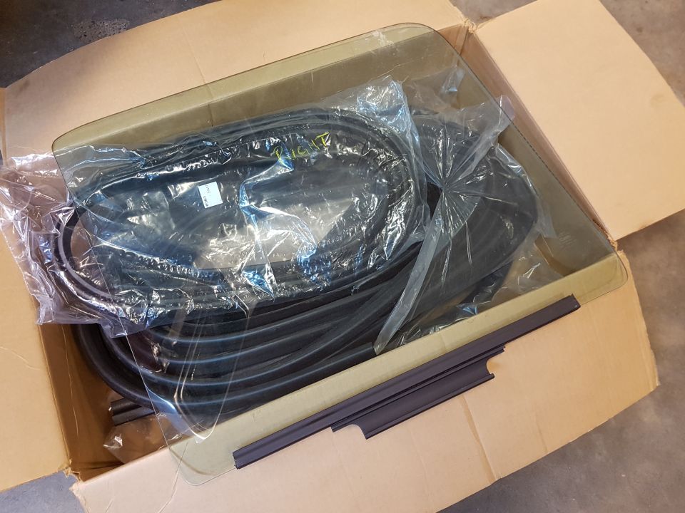 Box of car window seals and trim pieces, some still in plastic packaging