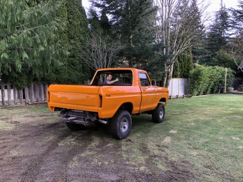 1978 Ford Bronco - Orange 1978 Ford F-150 pickup truck shown from the rear, with a person inside.