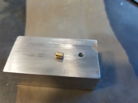 1978 Ford Bronco - A close-up view of a small brass fitting resting on a machined metal block.