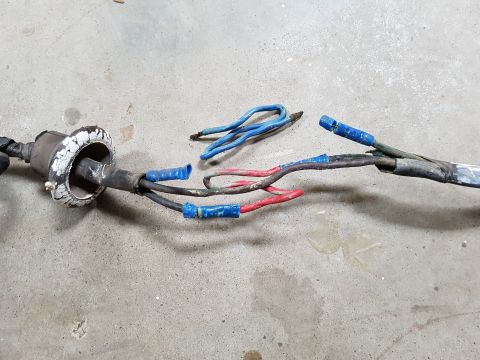 1978 Ford Bronco - A close-up view of a damaged wiring harness with exposed wires and blue crimp connectors.