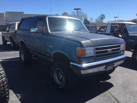 1979 Ford Bronco - This blue Ford Bronco is seen from a 3/4 front angle. The license plate is visible and reads 20210.