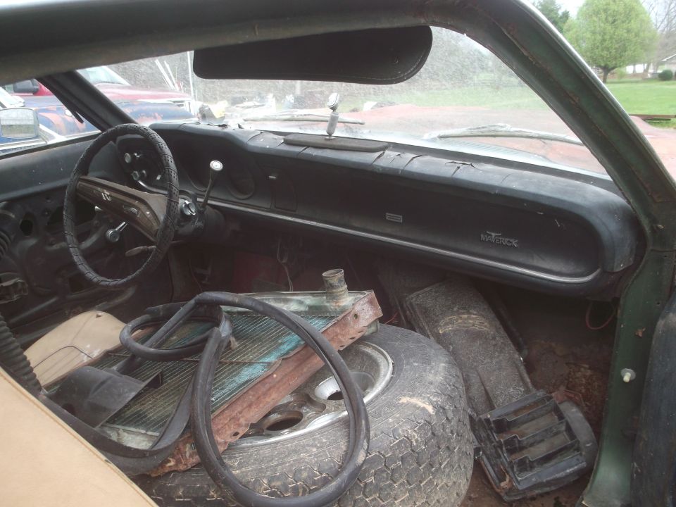 1972 Ford Maverick interior showing dashboard, steering wheel, spare tire, and radiator