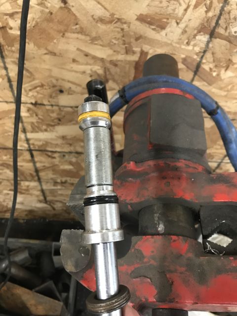 1984 Ford Bronco - A metal component is secured in a vise, with blue hoses visible in the background.