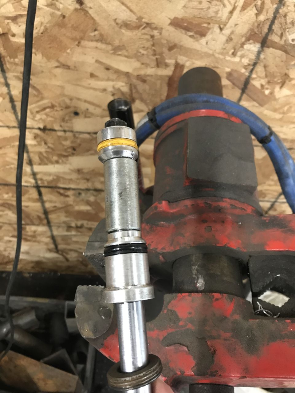 Metal part with yellow and black bands held in a red vise