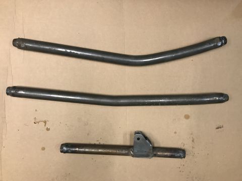 1984 Ford Bronco - Metal exhaust pipes and a bracket are shown on a brown surface. The Supermotors.net logo is in the lower right corner.