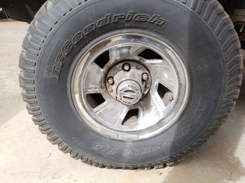 1978 Ford Bronco - A close-up view of a BFGoodrich All-Terrain T/A tire and chrome wheel assembly.