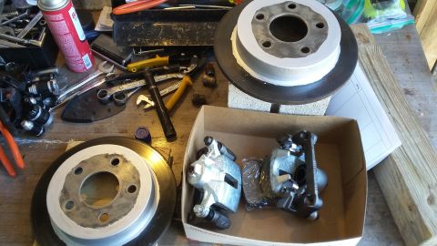 Brake rotors and calipers with tools on a workbench