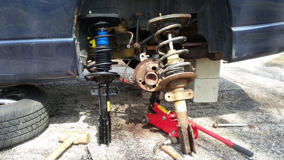 New and old front struts for a vehicle, one with a blue spring