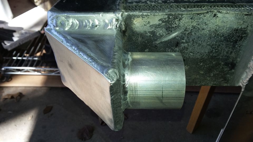 Custom aluminum intercooler piping with visible welds and a metal tube outlet
