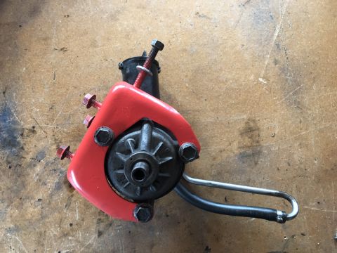 1978 Ford Bronco - A red power steering pump assembly is shown on a workbench.