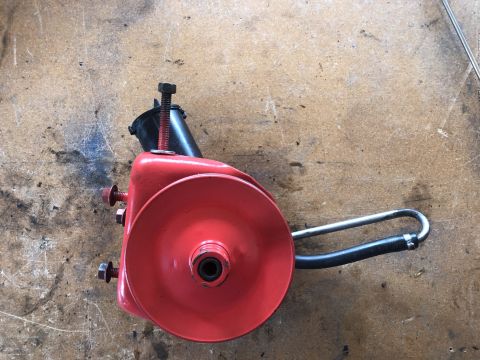 1978 Ford Bronco - This red power steering pump assembly includes a pulley and a black hose attached to a metal loop.