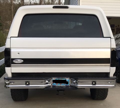 1995 Ford Bronco - The rear of a white 1995 Ford Bronco is parked in front of a garage.