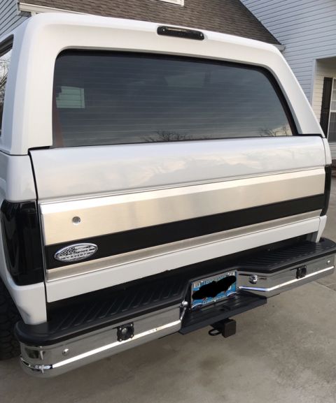 1995 Ford Bronco - Rear view of a white Ford Bronco, showing its chrome bumper and tinted rear window.