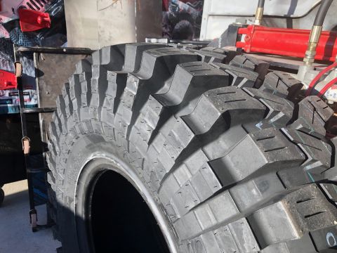 1992 Jeep Wrangler - This image shows a close-up view of a off-road tire with deep, aggressive tread patterns.