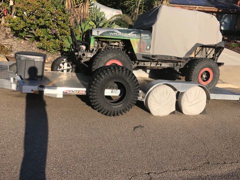 1992 Jeep Wrangler - A modified Jeep Wrangler is loaded onto a trailer, with a spare tire placed beside it.