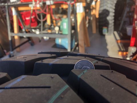 1992 Jeep Wrangler - A close-up view of a tire's tread pattern, with a quarter placed in one of the grooves for size comparison.