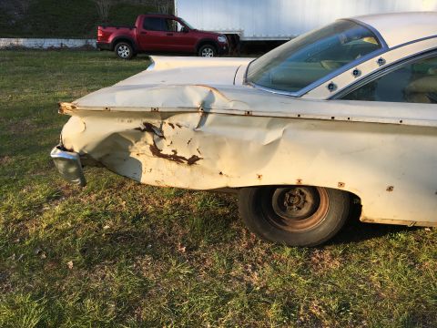 1960 Ford Starliner - This heavily damaged white car, likely a 1959 model, shows significant rear quarter panel damage and a chrome bumper.