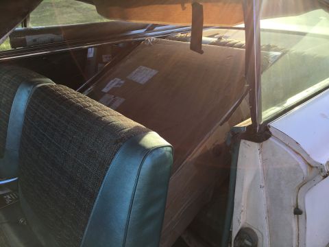 1960 Ford Starliner - Boxes are stacked in the back of a car with green patterned seats.
