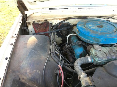 1960 Ford Starliner - Close-up of a car's engine bay, showing the air cleaner and coolant overflow tank.
