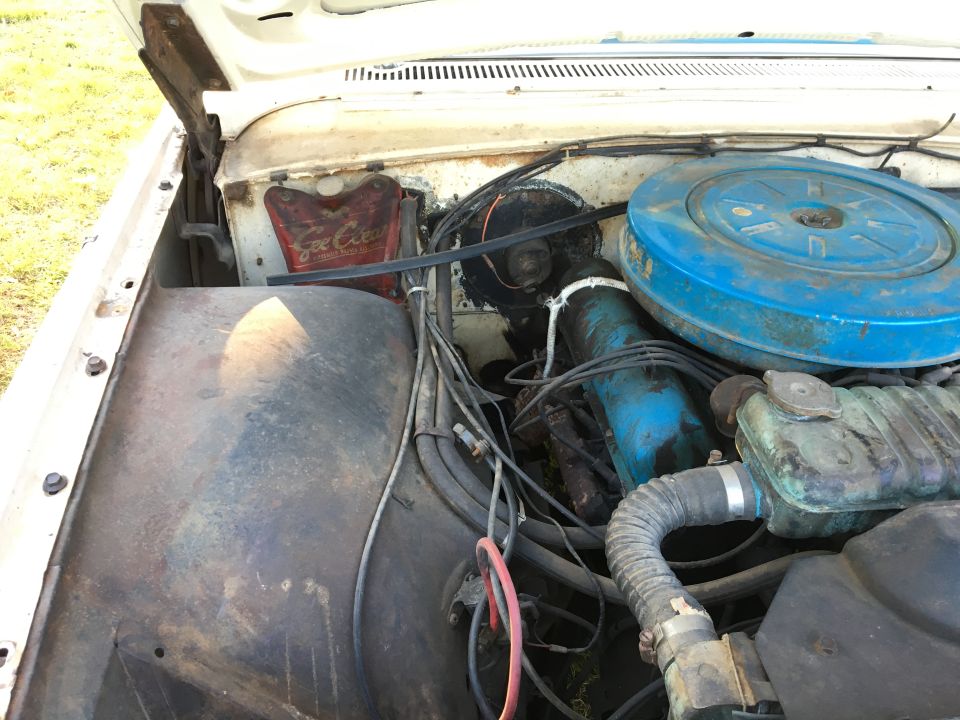 Engine bay with blue air cleaner and red Coca-Cola coolant overflow tank