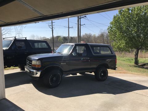 2008 Ford Focus - Two Ford Broncos are visible, one dark gray and one black, parked outdoors under a covered area.