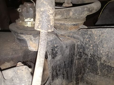 1985 Ford Bronco - This image shows a close-up view of a vehicle's suspension system, focusing on the coil spring and its mounting points.