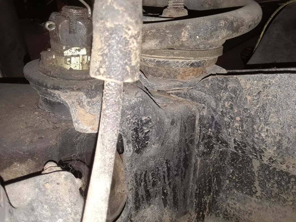 Close-up of a vehicle's suspension system, showing a coil spring and mounting hardware
