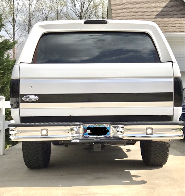 1995 Ford Bronco rear view, white with black stripe, chrome bumper, aftermarket wheels