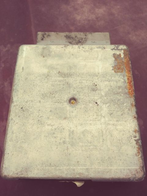 1996 Ford Bronco - A metal automotive computer module is shown, with some visible text and signs of rust.