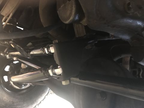 1984 Ford Bronco - Close-up of the steering and suspension system, showing various metal rods and bolts.