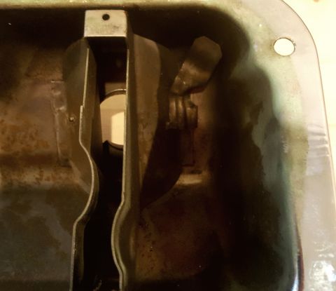 1973 Ford Mustang - Close-up view of the inside of an oil pan, showing internal components.