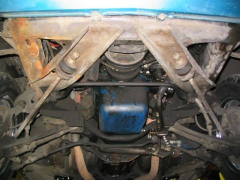 1969 Mercury Cougar - Undercarriage view shows the front suspension components and a blue oil pan, with visible rust on the frame.