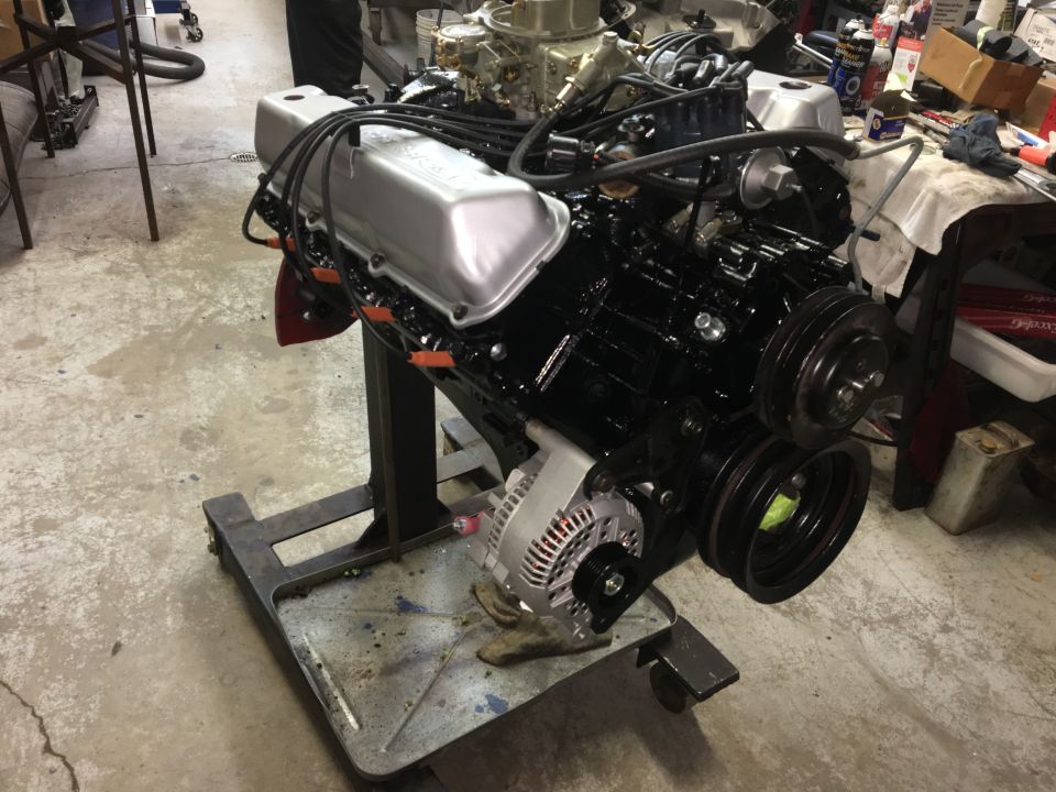 V8 engine on a stand, showing alternator, pulleys, and valve covers