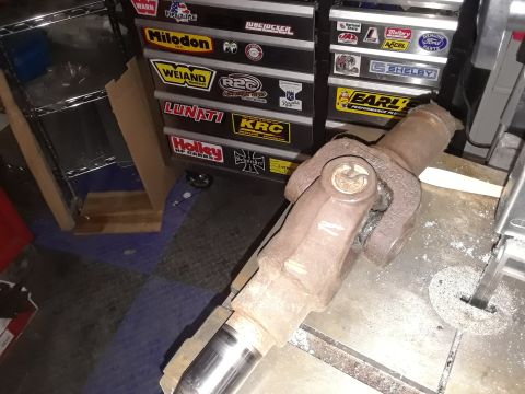 1985 Ford Bronco - A worn driveshaft U-joint is shown in a workshop setting, with various tool chest stickers visible.
