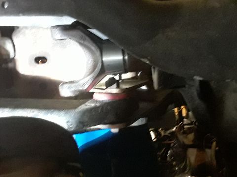 1985 Ford Bronco - Underside view of a red suspension bushing and associated metal components.