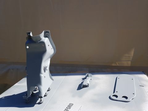 1978 Ford Bronco - Several automotive parts are laid out on a white surface, appearing to be freshly painted.