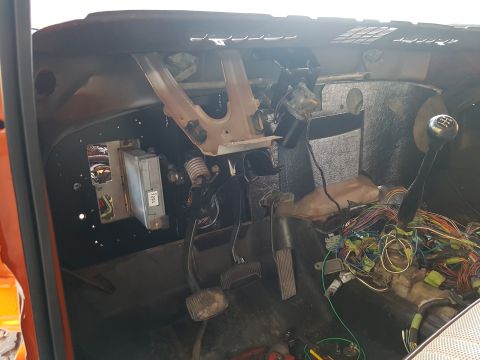 1978 Ford Bronco - The vehicle's interior is disassembled, revealing the complex wiring harness and components beneath the dashboard.