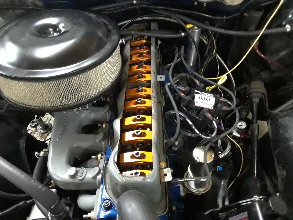 Engine bay with air cleaner, valve covers, and wiring visible