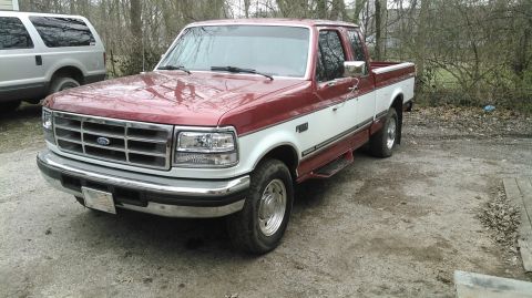 1996 Ford F-250 - Two-tone red and white 1996 Ford F-250 pickup truck parked outside with another vehicle in the background.