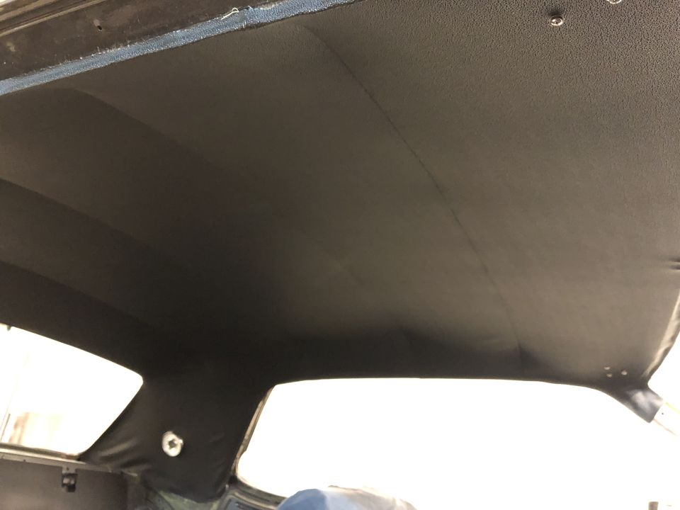 Car headliner with visible seams and mounting points. Part of a car interior