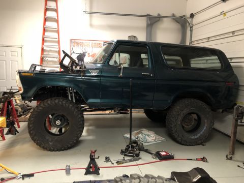 1979 Ford Bronco - This 1979 Ford Bronco is undergoing modifications in a garage, with its hood up and tools nearby.