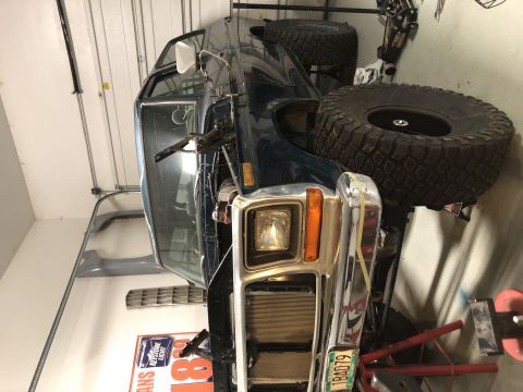 1979 Ford Bronco - SUV with a chrome grille and prominent off-road tires is shown from the front.