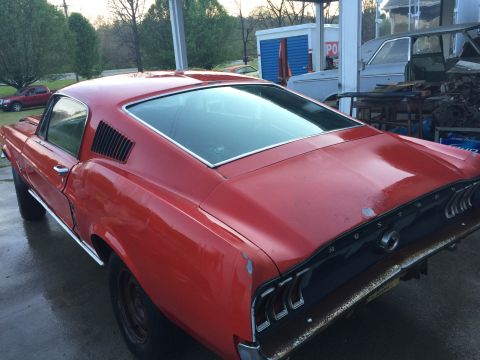 1967 Ford Mustang - Rear view of a red 1967 Ford Mustang fastback, showing the 'MUSTANG' badging on the trunk lid.