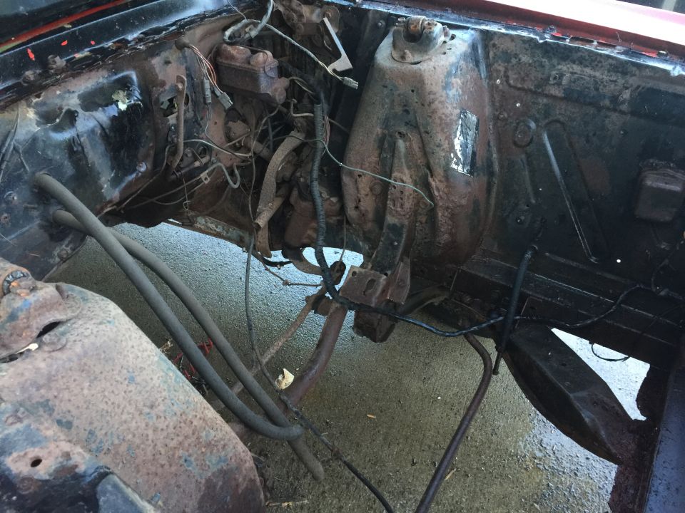 1967 Ford Mustang engine bay with rusted components and exposed wiring
