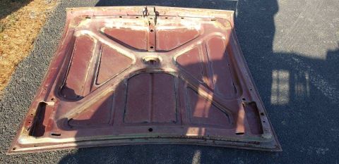 1962 Ford Galaxie - The underside of a car hood, showing its internal structure and signs of age.