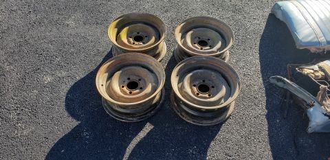 1962 Ford Galaxie - Four steel wheels and parts of a car seat are visible on an asphalt surface.