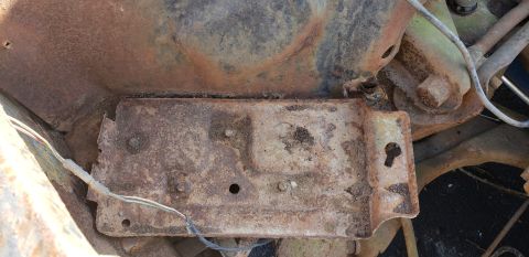 1962 Ford Galaxie - Close-up of a heavily rusted metal bracket with wires, likely from a vehicle's chassis.
