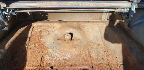 1962 Ford Galaxie - The interior of a car trunk shows significant rust and wear.