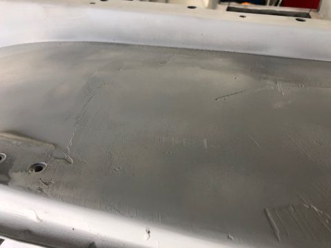 1992 Jeep Wrangler - Close-up of a primed car body panel, likely undergoing repair or preparation for paint.